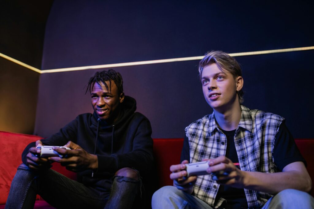 Two young men playing video games on the couch.