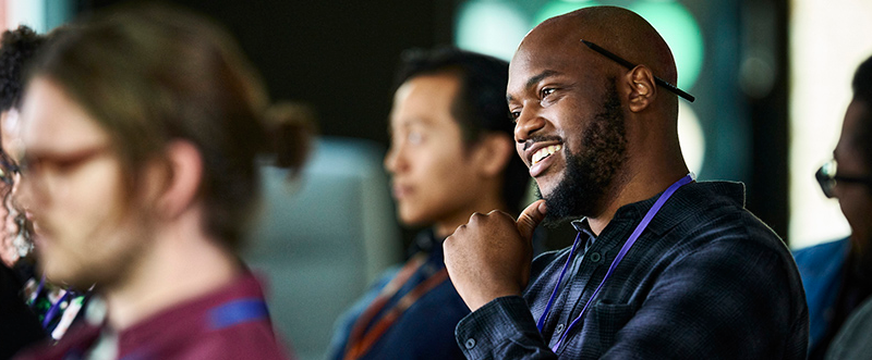 Man sitting in an audience, looking ahead with interest.