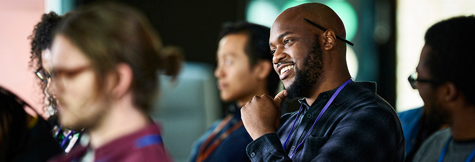Man sitting in an audience, looking ahead with interest.